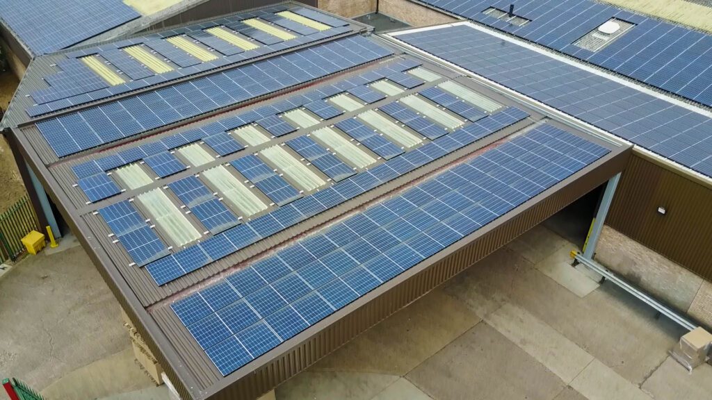 Solar-paneled rooftops with translucent areas for lighting, showcasing sustainable energy use in buildings.