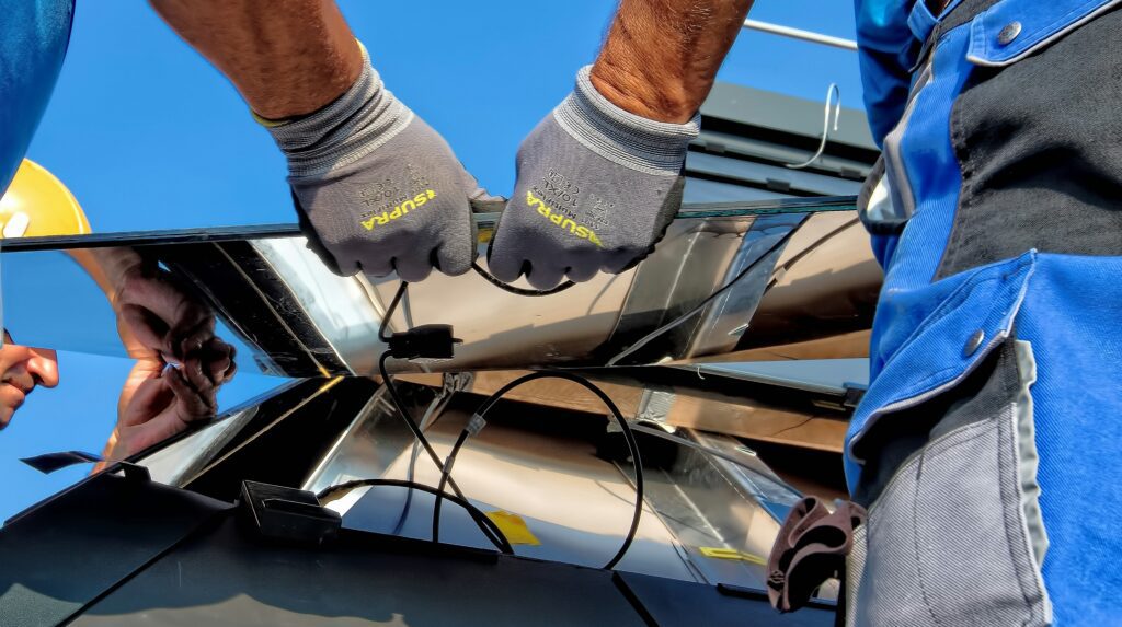 Solar panel work: two individuals inspecting and connecting wires on panels, promoting renewable energy use.