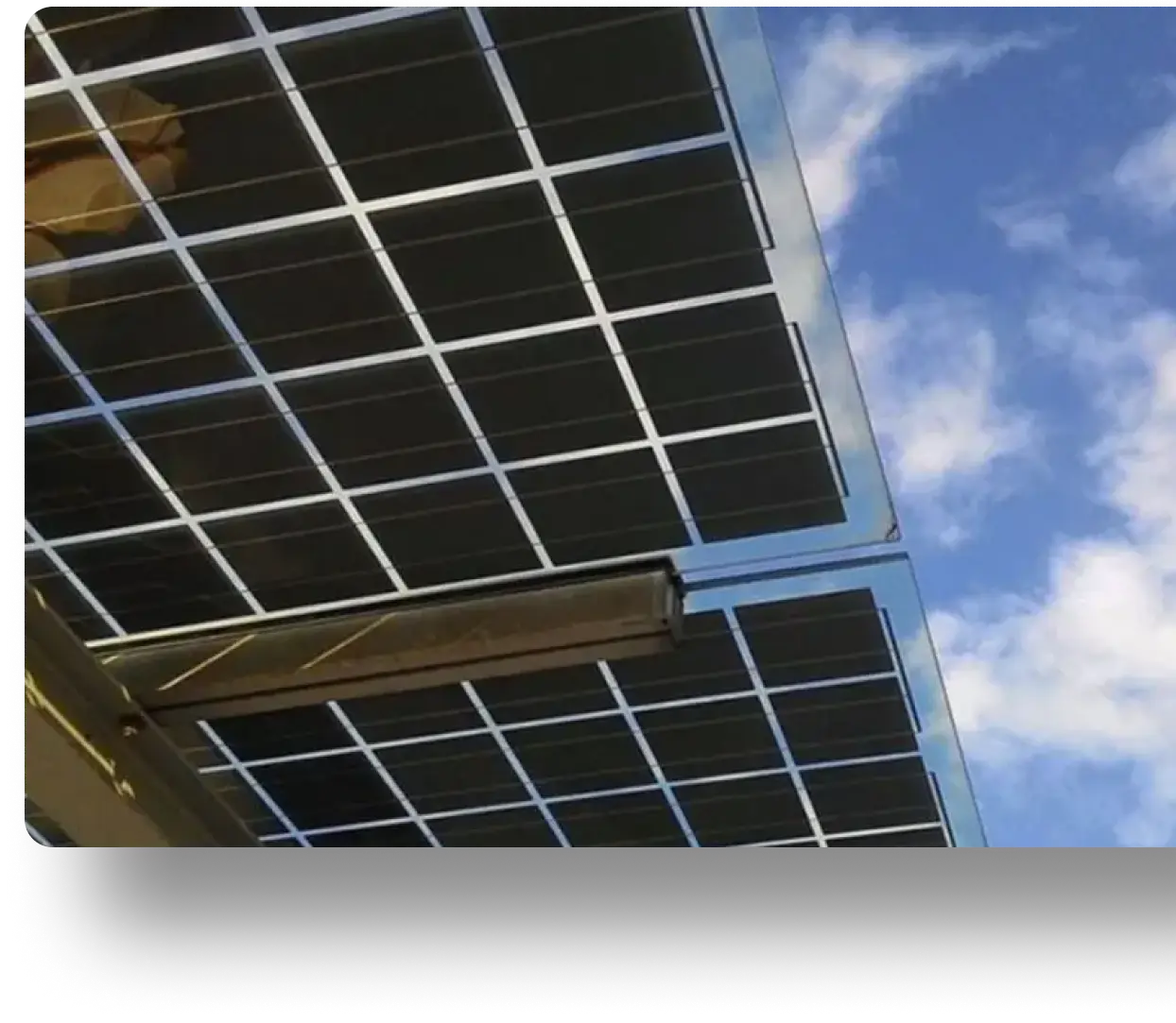 Angled solar panels on a metal structure beneath a partly cloudy sky, harnessing renewable energy.