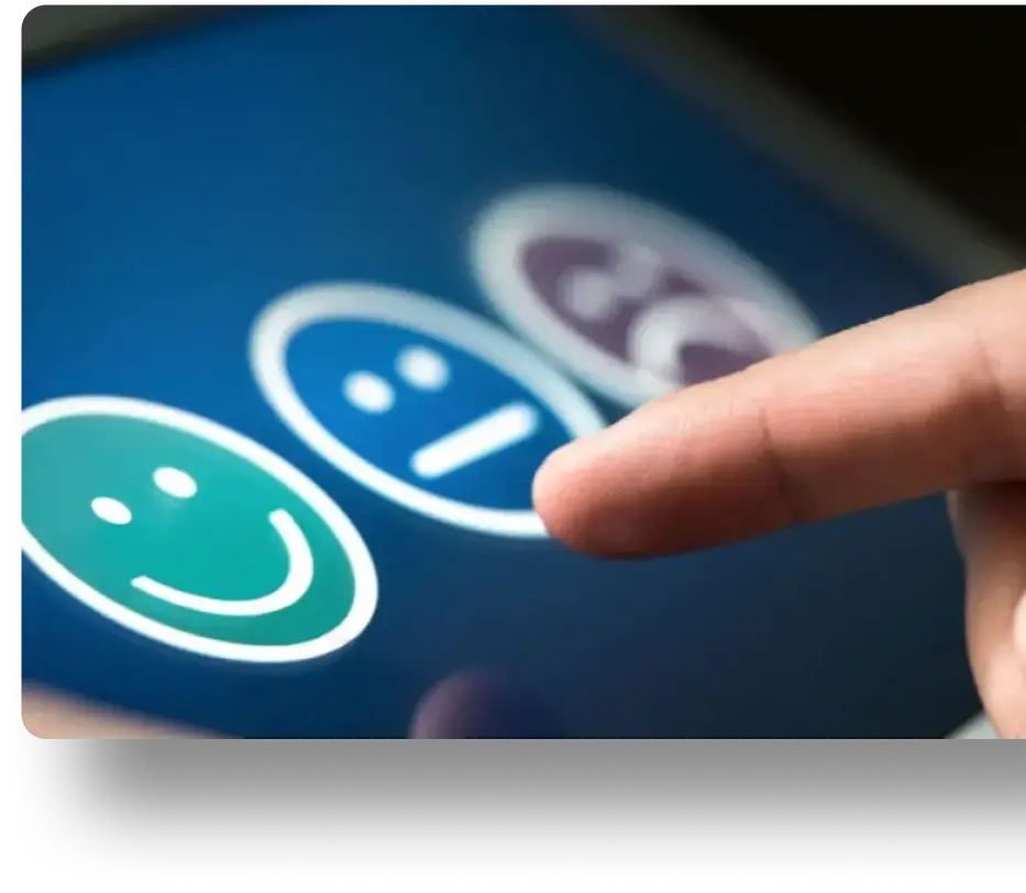 The image depicts a finger interacting with a touchscreen that displays three smiley faces.