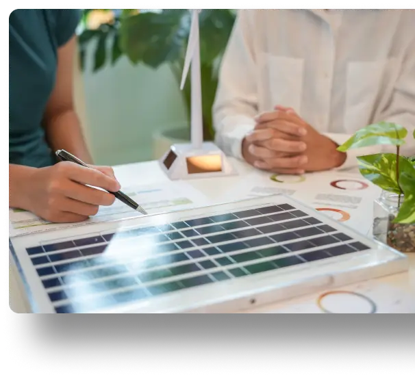 Two people discussing renewable energy models with diagrams and notes on a table.