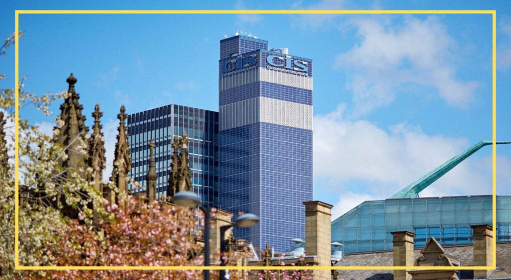 Modern skyscraper with 'CIS' and 'Cooperative Insurance' text, surrounded by historic buildings and pink trees.