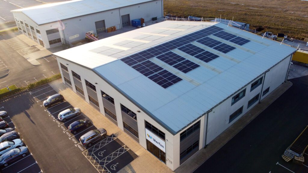 Aerial view of a commercial building with solar panels, large windows, and 'Werfen' signage near the entrance.