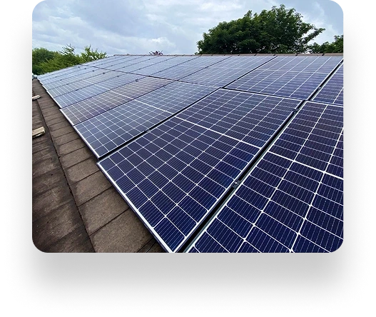 Solar panels on a rooftop in Alt Valley, arranged in rows under a cloudy sky with trees in the background.