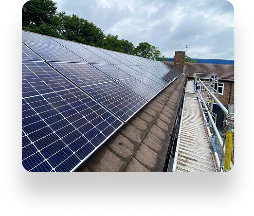 Rooftop solar panels on an Alt Valley home cover a sloped roof. Scaffolding on the right and trees under a cloudy sky add to the serene scene.