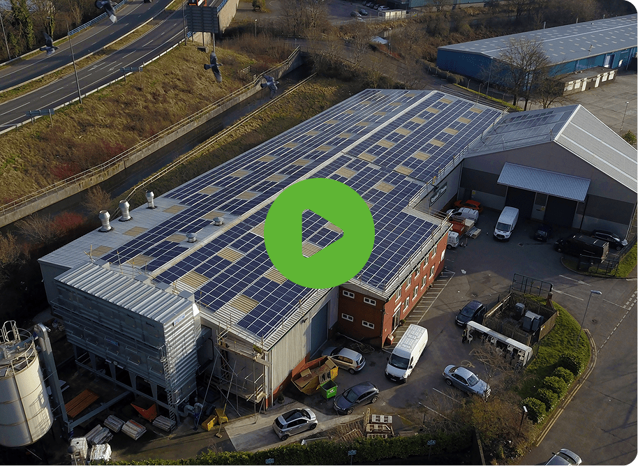 Aerial view of an industrial building with solar panels, indicating eco-friendliness. Crystal Doors vehicles are parked around. A central green play button invites exploration.