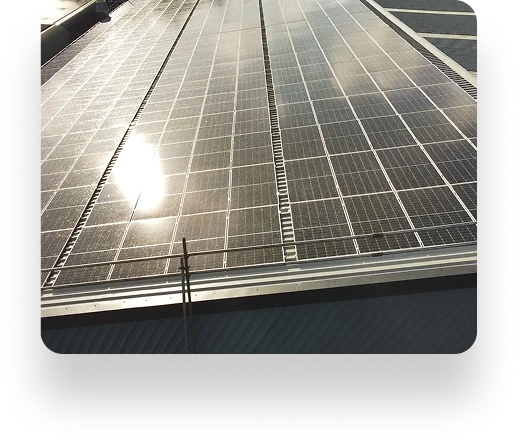 Large array of Datim solar panels on a rooftop reflecting sunlight, aligned in neat rows to efficiently capture solar energy.