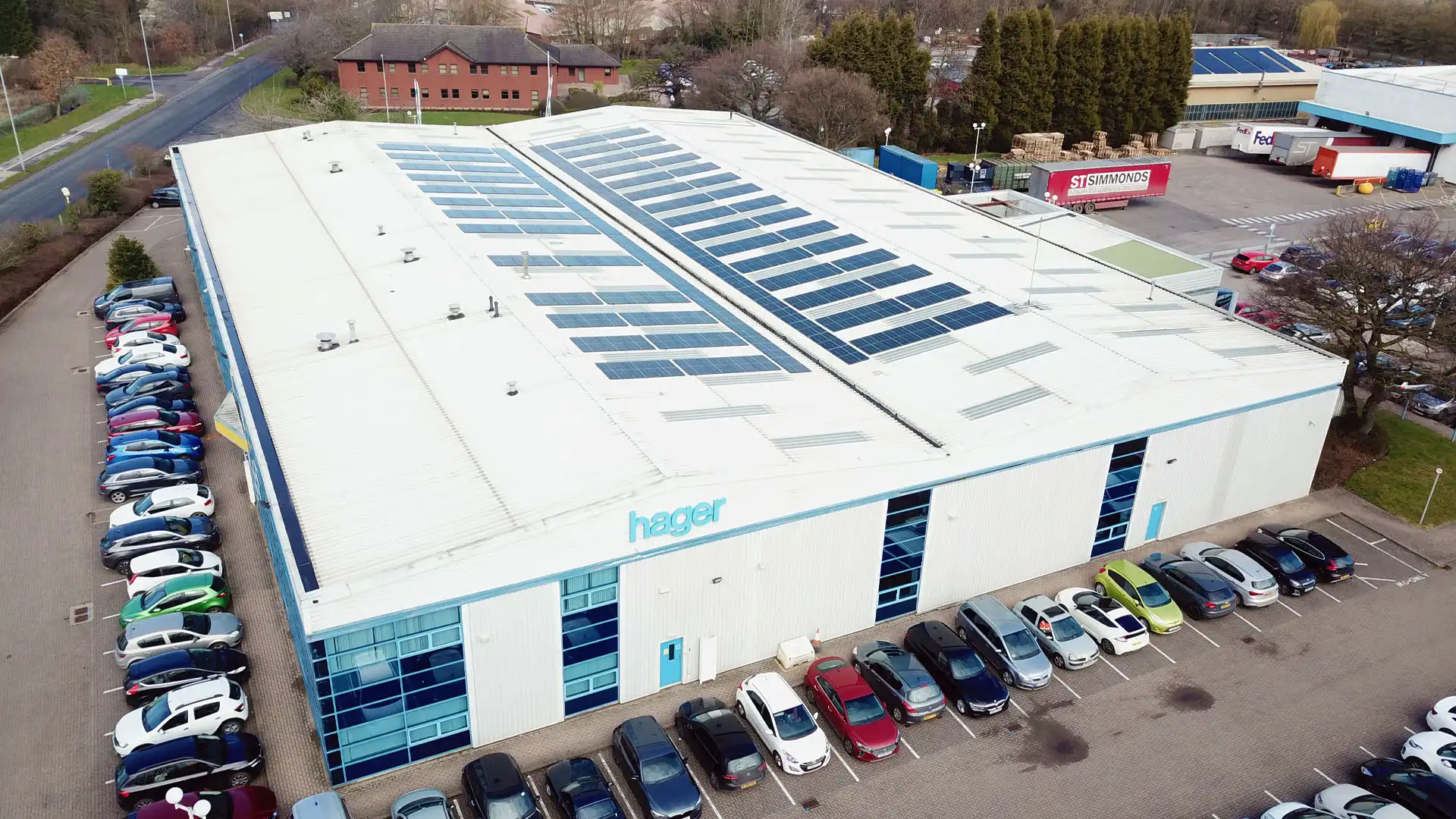 This is an aerial view of a large industrial building with solar panels on its roof.