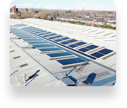 Under a clear sky, a rooftop of a Laltex Group building is lined with solar panels. Factory buildings and the cityscape can be seen stretching into the background.