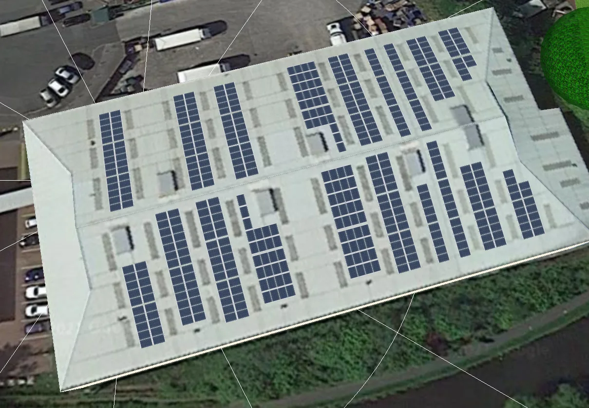 Building with rows of solar panels on its roof, surrounded by greenery and a parking lot.