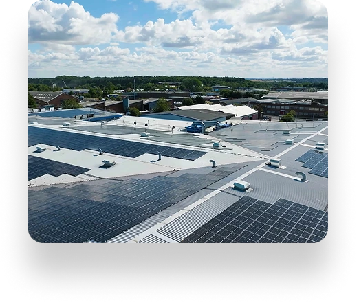 Rooftop with solar panels under a partly cloudy sky, overlooking Linney buildings and lush greenery in the background.