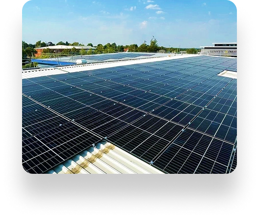 Solar panels on a rooftop under a clear blue sky, providing clean energy. In the distance, the Linney building is visible among trees, highlighting an eco-friendly setting.