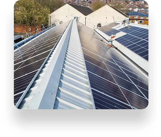 Rooftop solar panels from TBE Precision align perfectly under a clear sky on a metal roof, surrounded by trees and neighboring rooftops in the background.