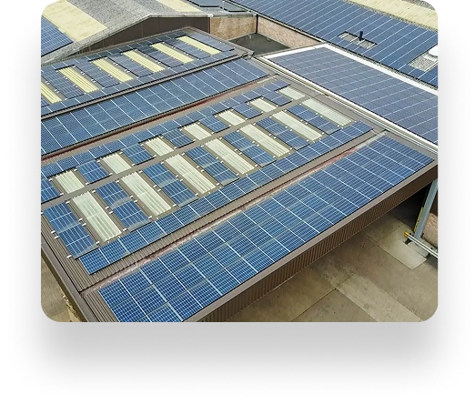 Rooftop of The Box Factory with parallel rows of solar panels, efficiently capturing sunlight. The industrial building has a flat, expansive roof and minimal surroundings.