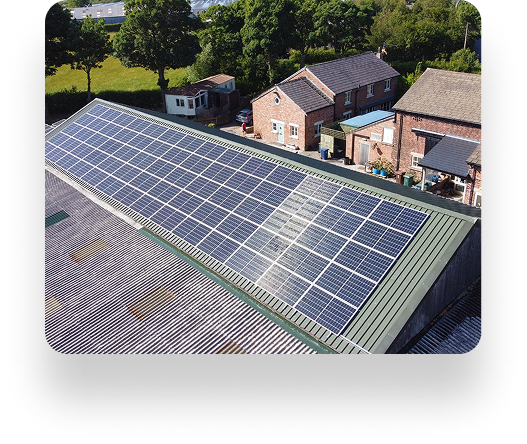 Rooftop solar panels at The Farm Burscough on a sloped roof, surrounded by trees and houses. Panels are arranged in rows to efficiently capture sunlight.