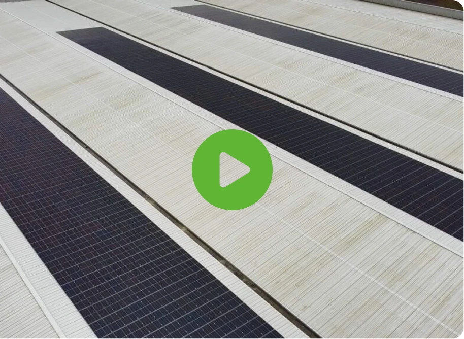 Rows of rooftop solar panels with black and white sections show TVS Supply Chain Solutions innovation. A large green play button icon suggests interactive media.
