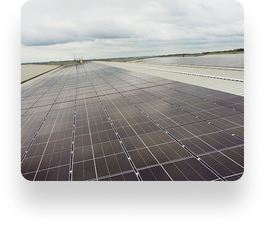 Solar panels on an expansive flat rooftop under a cloudy sky, arranged in rows and managed by TVS Supply Chain Solutions for a large-scale solar energy project.