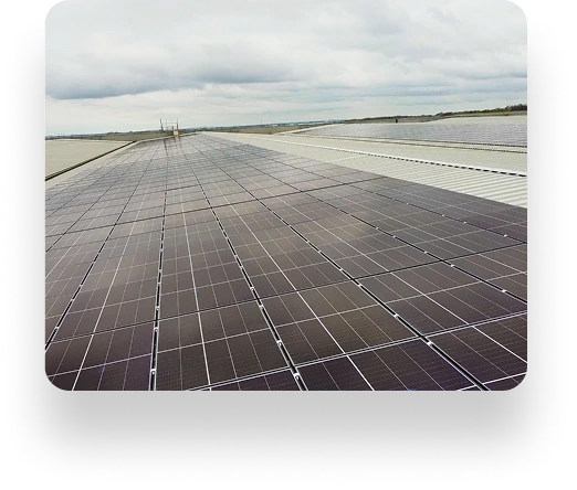 Solar panels on an expansive flat rooftop under a cloudy sky, arranged in rows and managed by TVS Supply Chain Solutions for a large-scale solar energy project.
