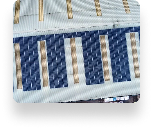 Aerial view of a WePack rooftop with parallel rows of solar panels, interspersed with light strips. Panels are uniformly aligned for efficient solar energy collection.