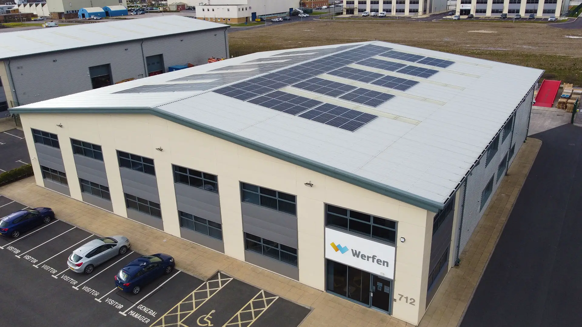 Large industrial building with solar panels, labeled 'Werfen 712,' and parking spaces.