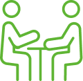 Two green outline figures sitting across from each other at a table, symbolizing discussion or meeting.