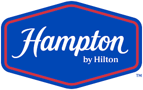 Hampton by Hilton logo: "Hampton" in white script, "by Hilton" below, on blue hexagon with red outline.