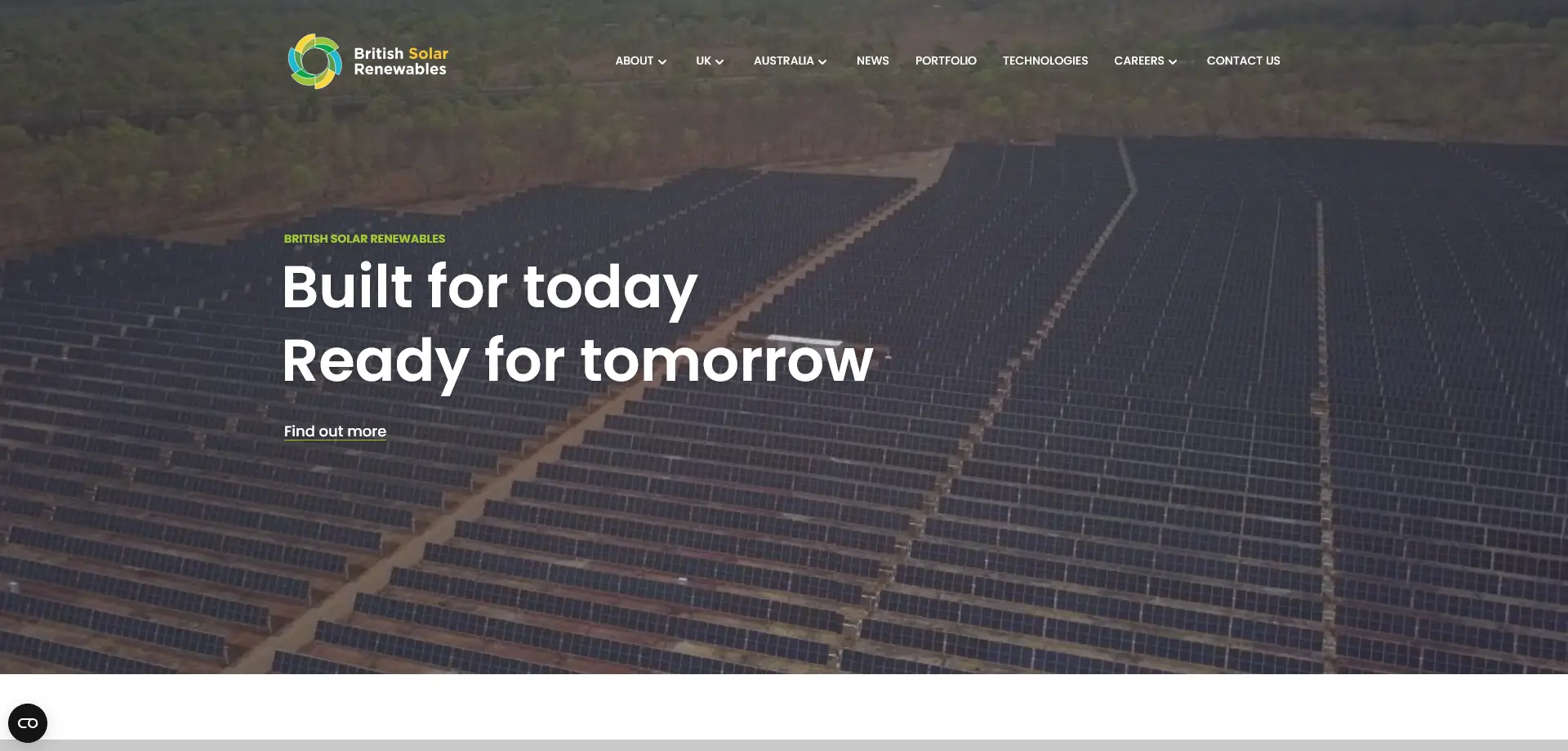 An aerial view of a large solar farm with rows of solar panels arranged in a grid pattern, surrounded by forested areas.