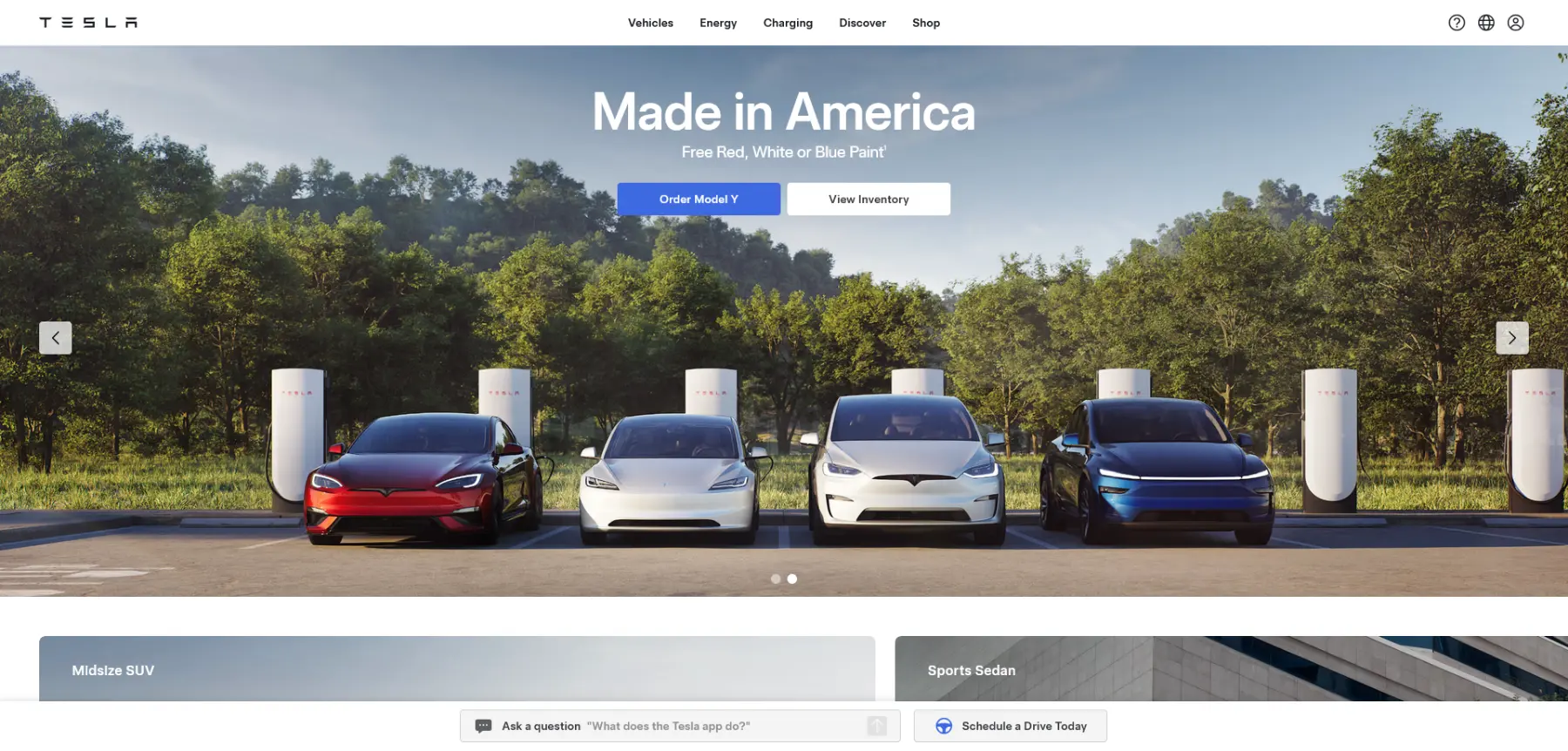 Tesla promotional banner showing red, white, and blue electric vehicles parked at charging stations with a forest backdrop. Text reads “Made in America” and offers free patriotic-colored paint options.
