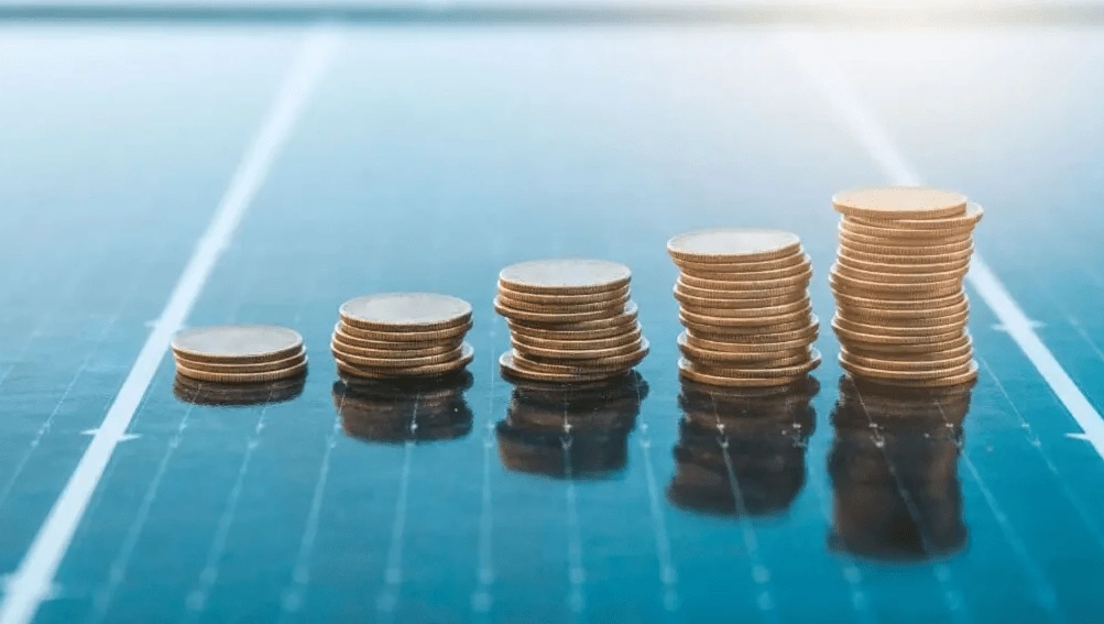 Five stacks of coins arranged in ascending height on a reflective surface.