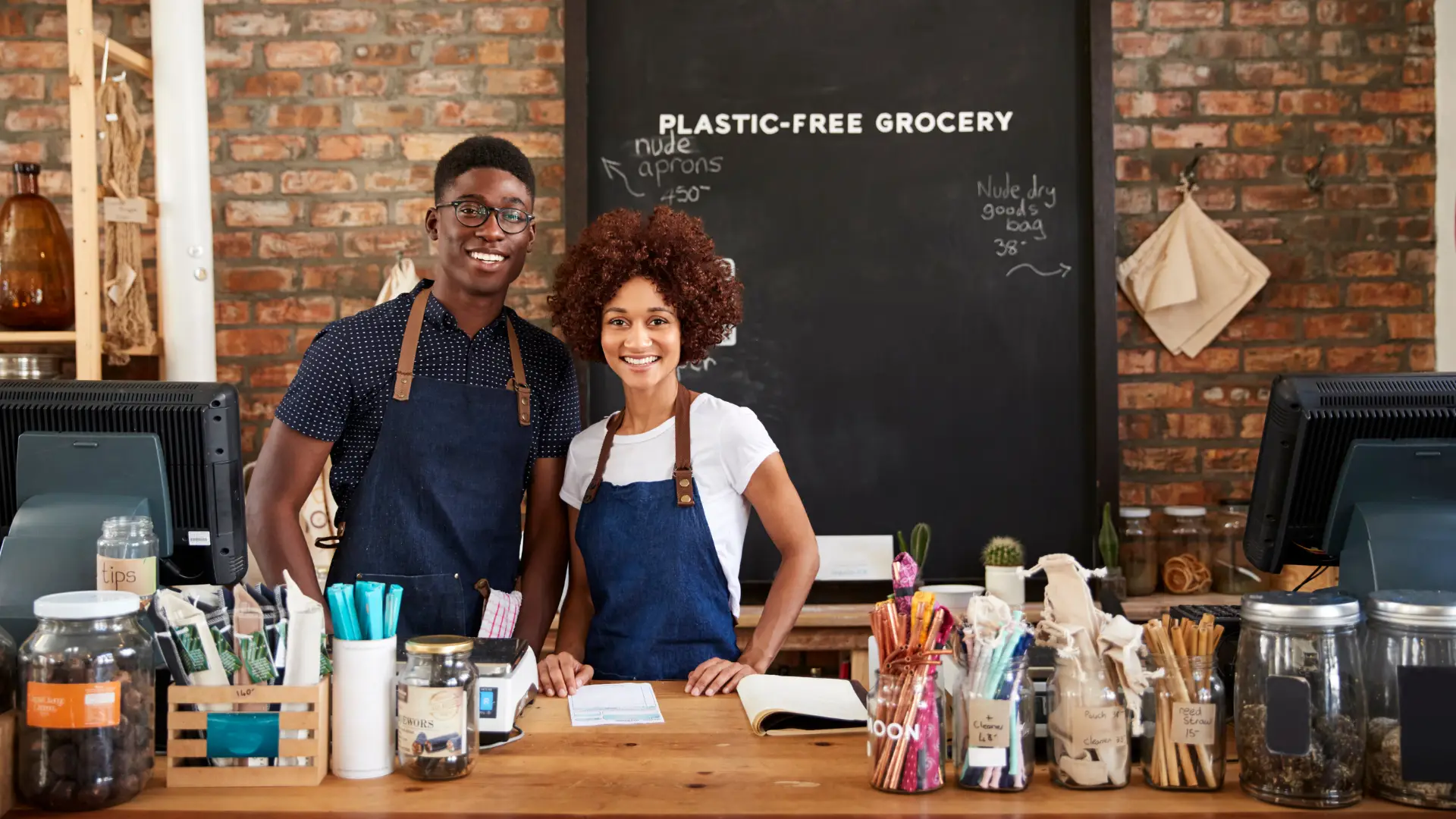 Two shop assistants behind the counter of a plastic-free grocery store.