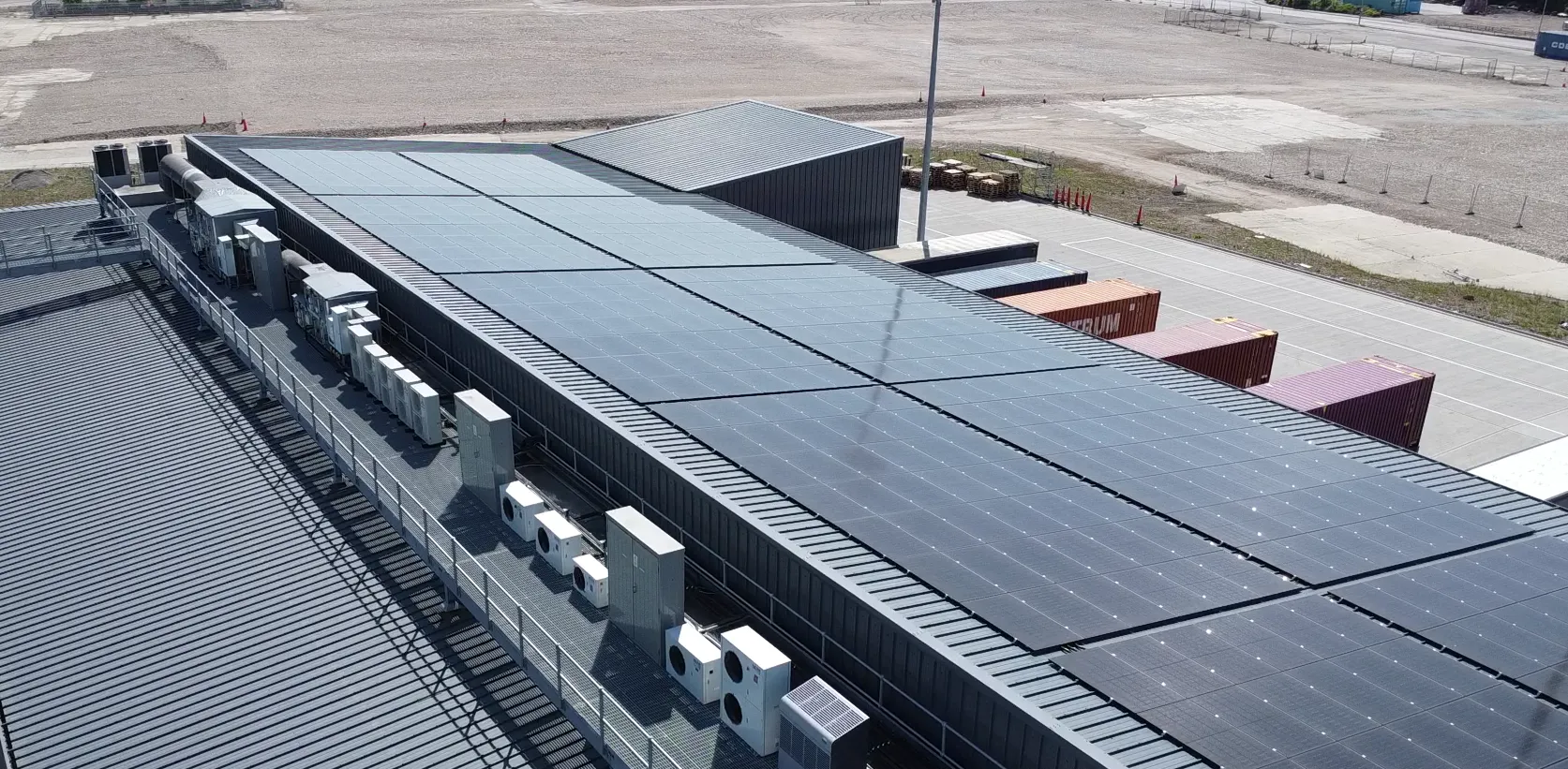 Solar panels on the roof of a CLdN building beside a container yard